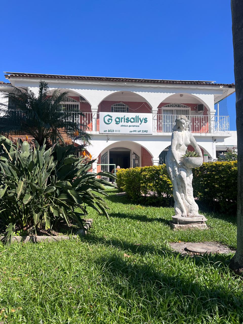 Fachada com estátua e jardim florido da Matriz