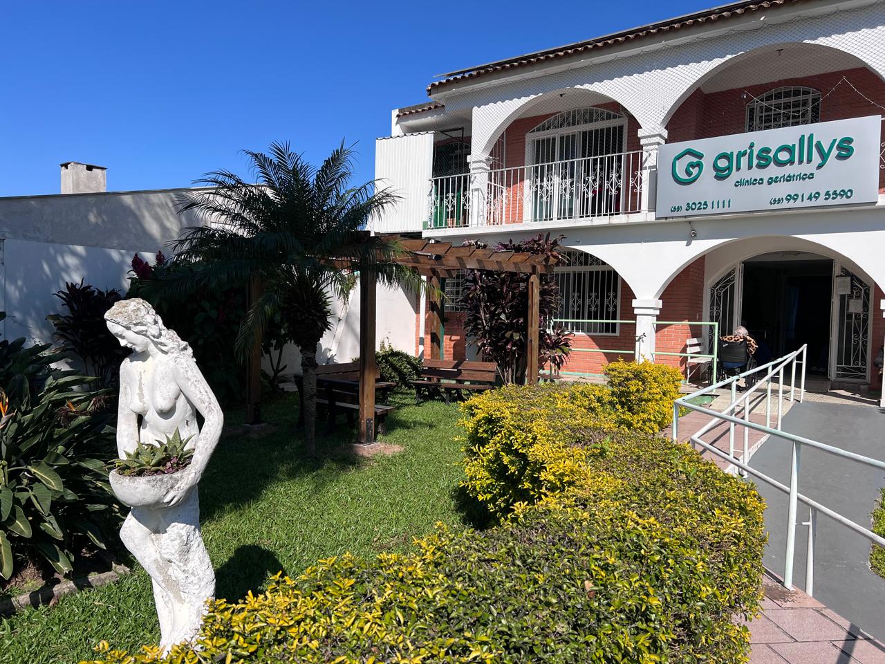 Jardim lateral com pérgola e palmeiras
