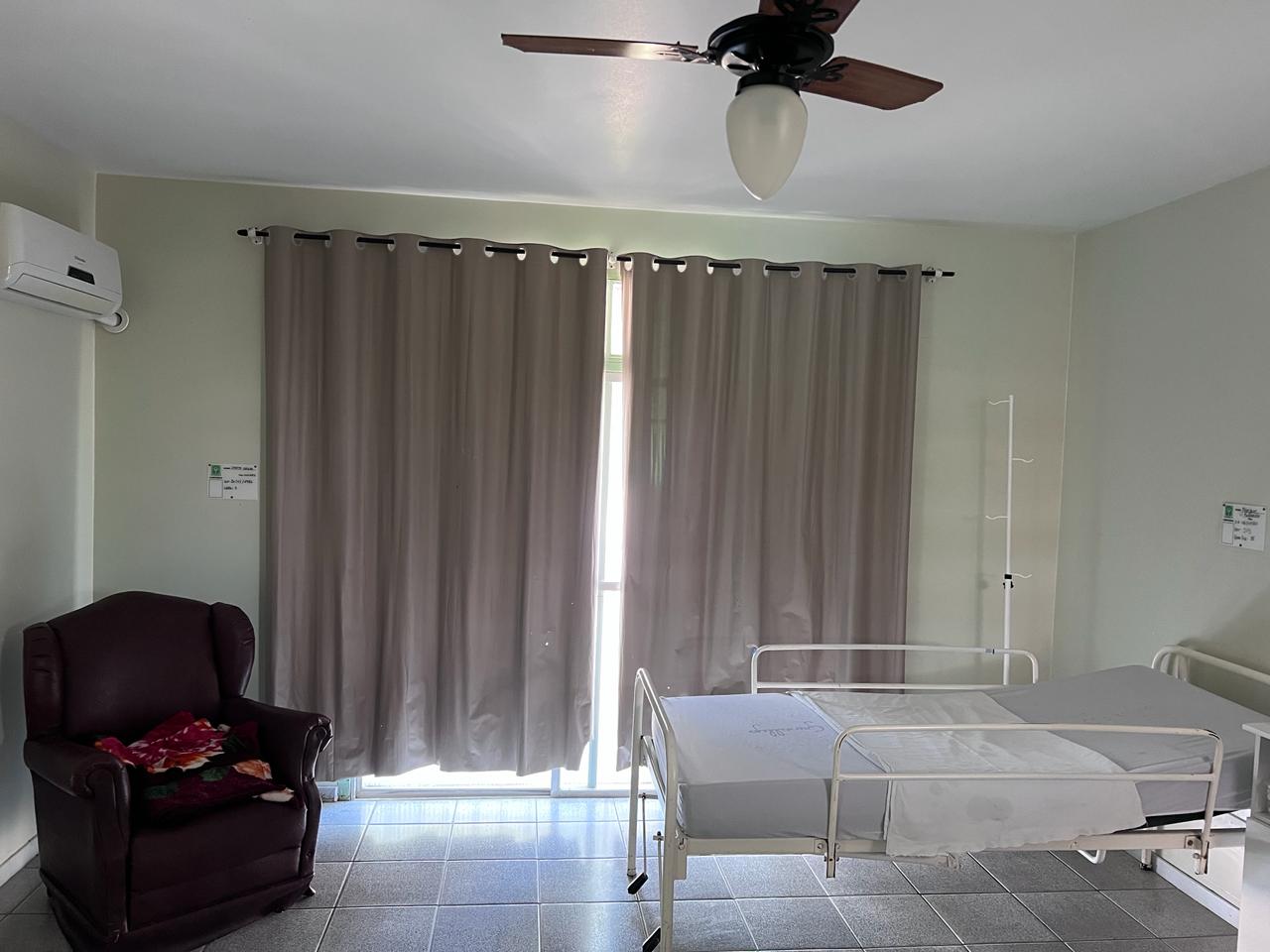 Quarto com cama hospitalar e poltrona de descanso