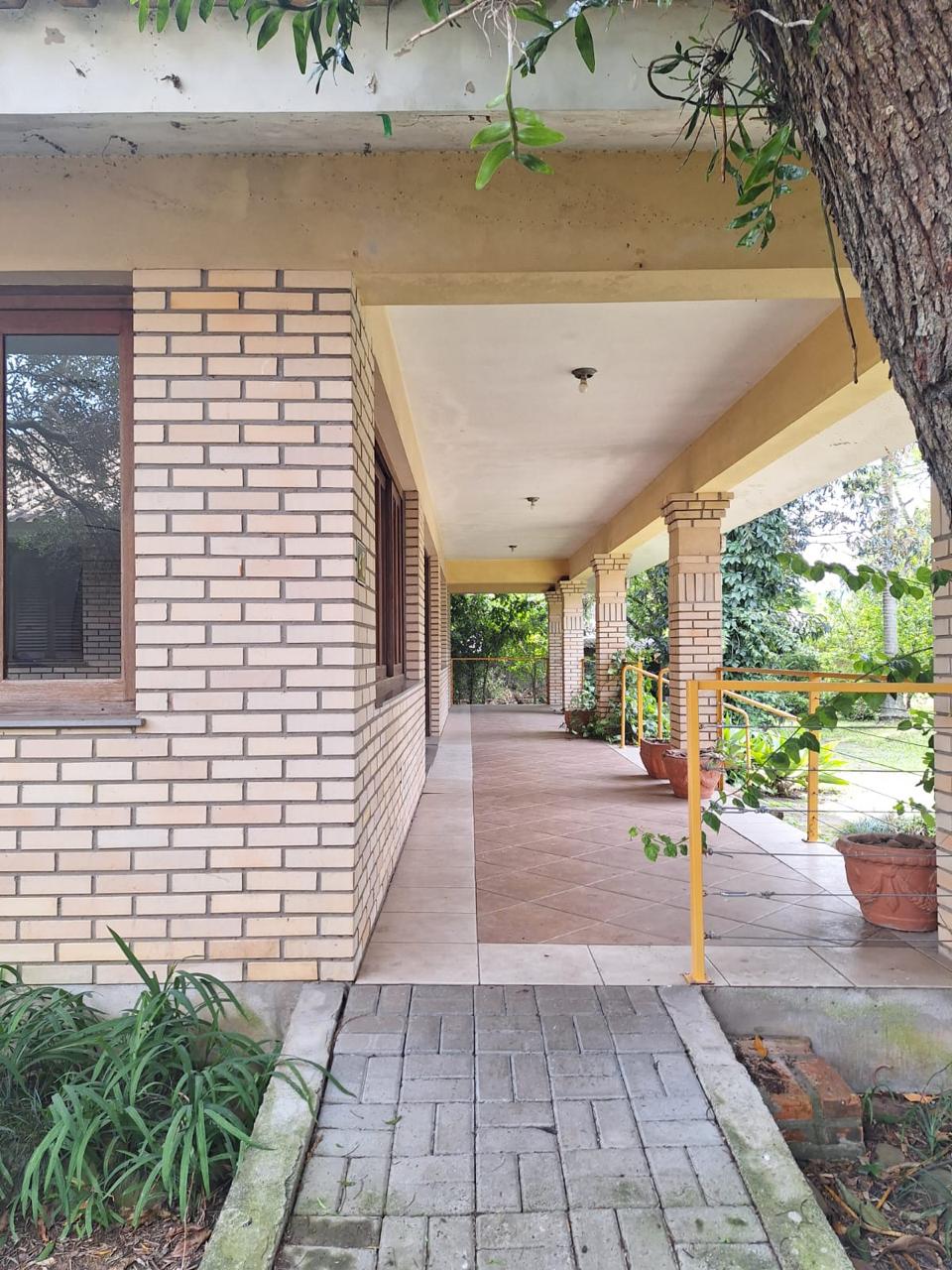 Varanda com colunas de tijolo e jardim